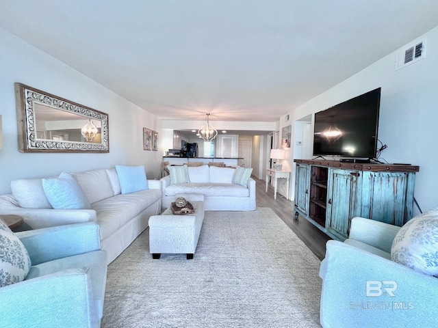 living room featuring a chandelier and wood-type flooring