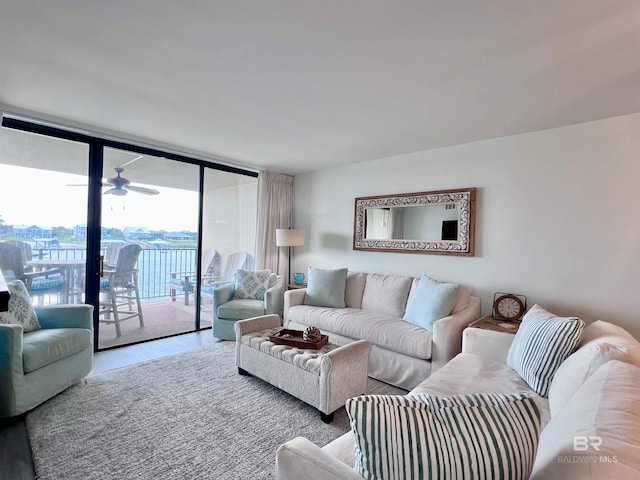 living room featuring ceiling fan and expansive windows