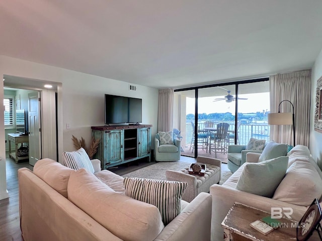 living room featuring ceiling fan, dark wood-type flooring, and floor to ceiling windows