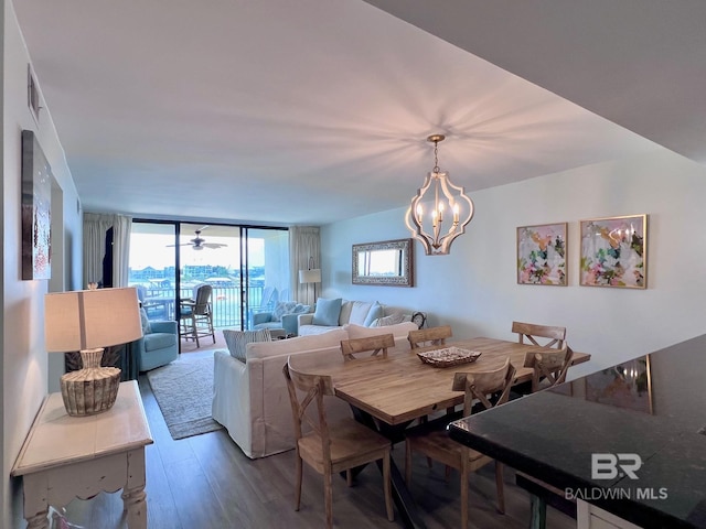 dining area with hardwood / wood-style flooring, an inviting chandelier, and a wall of windows