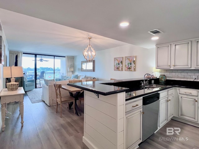 kitchen with light wood-type flooring, stainless steel dishwasher, floor to ceiling windows, sink, and kitchen peninsula