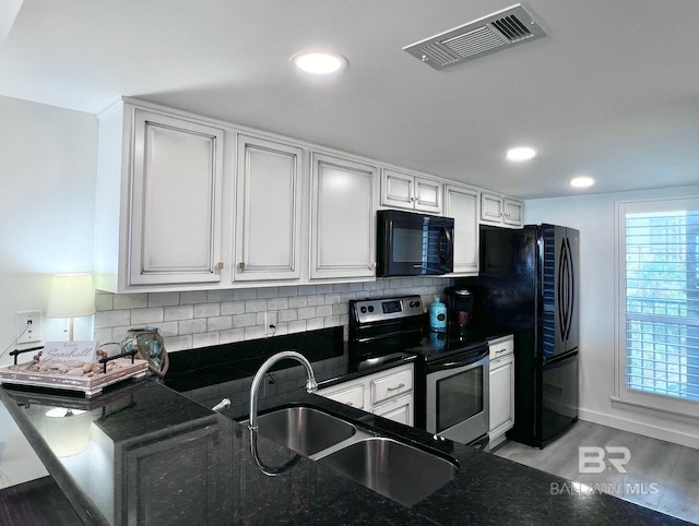 kitchen featuring sink, light wood-type flooring, kitchen peninsula, black appliances, and white cabinets