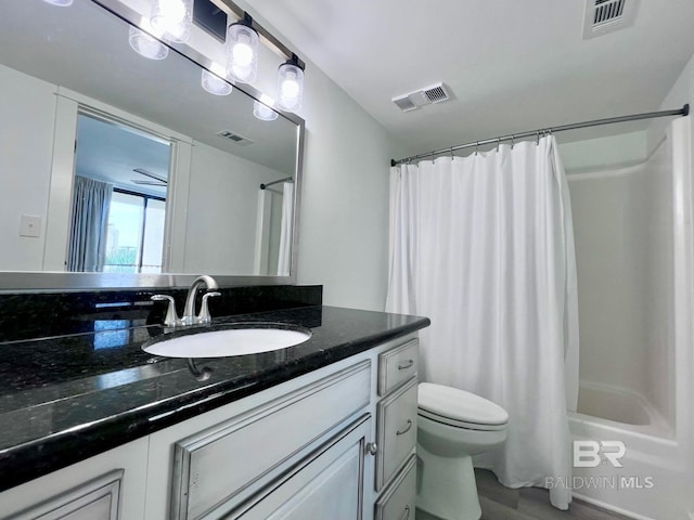 full bathroom featuring ceiling fan, vanity, shower / bath combo, and toilet