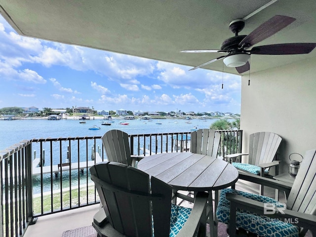 balcony with ceiling fan and a water view