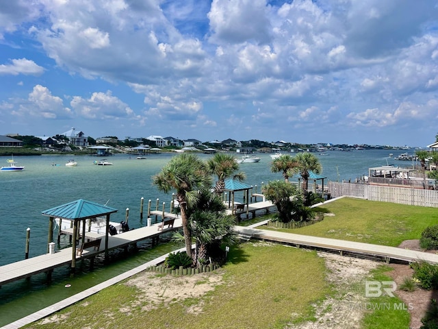 view of dock featuring a lawn and a water view