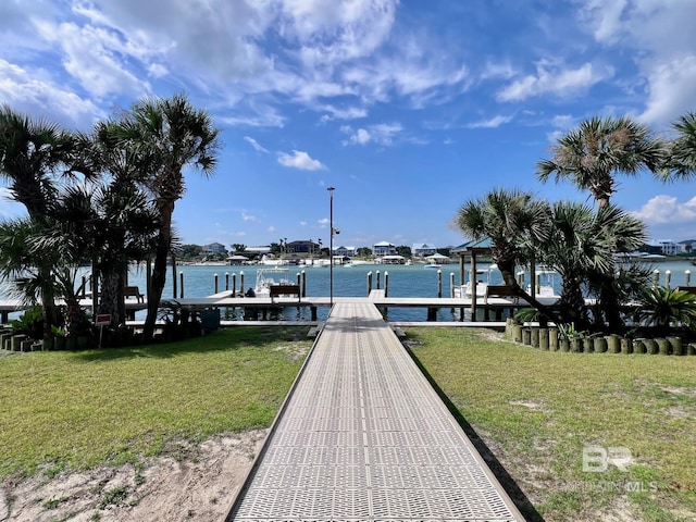 dock area with a lawn and a water view