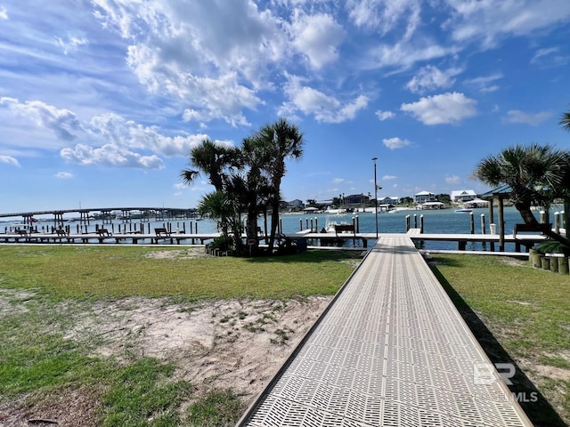 view of dock featuring a water view and a yard