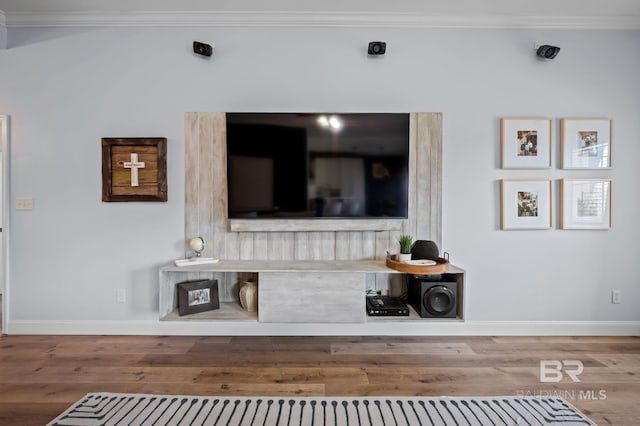 living room with crown molding, baseboards, and wood finished floors