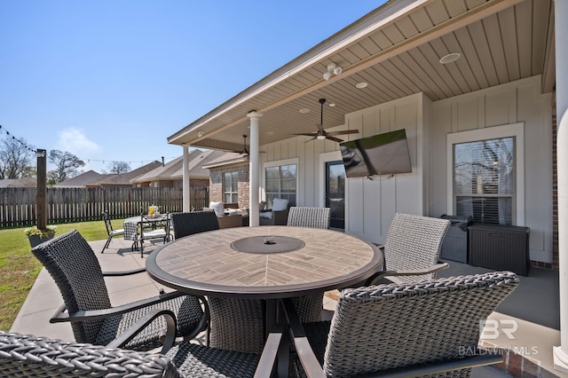 view of patio featuring outdoor dining area, a ceiling fan, and fence