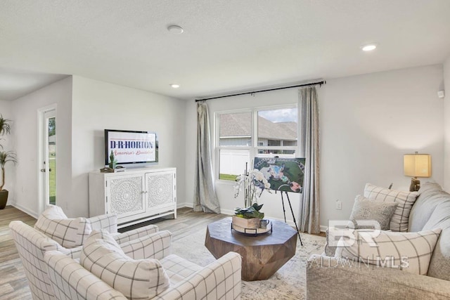 living room with a textured ceiling and light hardwood / wood-style floors