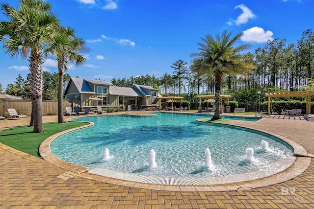 view of pool featuring pool water feature, a pergola, and a patio