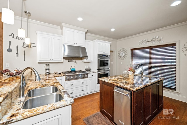 kitchen with sink, decorative light fixtures, dark hardwood / wood-style floors, stainless steel appliances, and light stone countertops