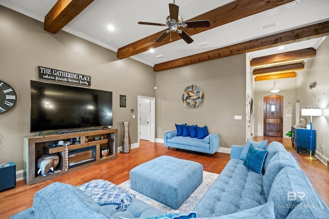 living room featuring ceiling fan, hardwood / wood-style flooring, and beamed ceiling