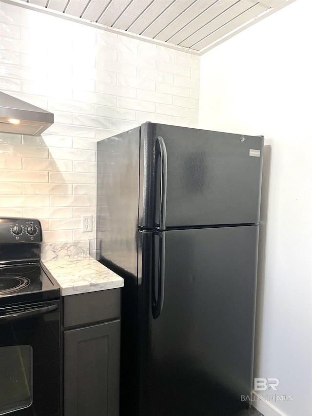 6 Yacht Club Dr Unit 115A, Daphne, AL 36526 - kitchen with light stone countertops, wall chimney range hood, backsplash, and black appliances
