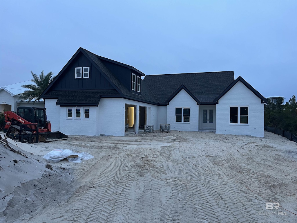 view of front of house with board and batten siding and a shingled roof