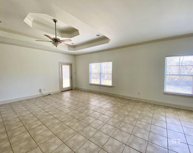 empty room featuring ceiling fan, ornamental molding, and a raised ceiling