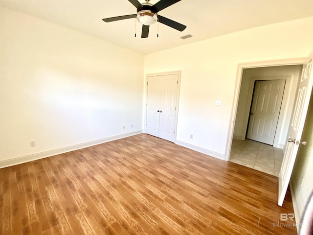 unfurnished bedroom with ceiling fan and light wood-type flooring