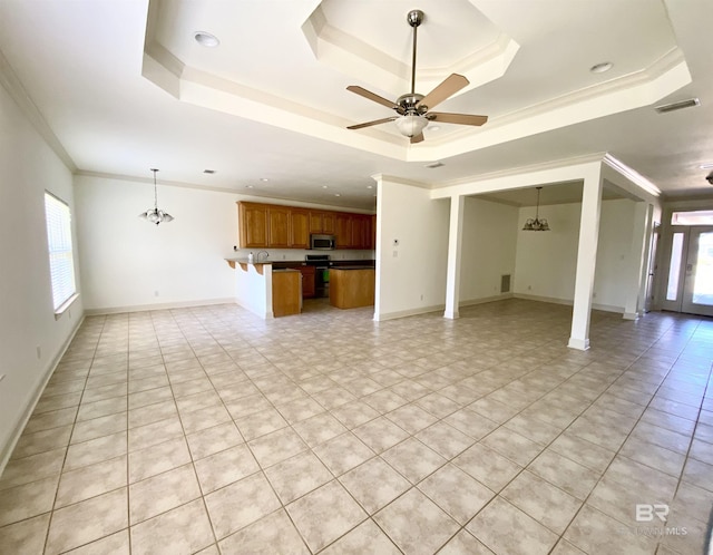 unfurnished living room with crown molding, a healthy amount of sunlight, ceiling fan with notable chandelier, and a tray ceiling