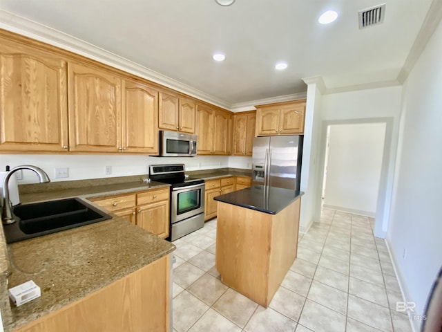 kitchen with sink, dark stone countertops, ornamental molding, a kitchen island, and stainless steel appliances