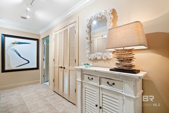 corridor featuring light tile patterned floors, crown molding, and rail lighting