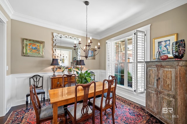 dining area with ornamental molding, an inviting chandelier, and dark hardwood / wood-style flooring