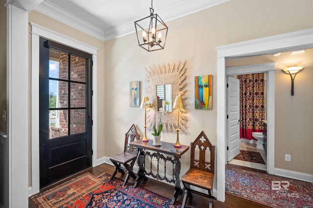 foyer entrance featuring a notable chandelier, dark hardwood / wood-style floors, ornamental molding, and a wealth of natural light