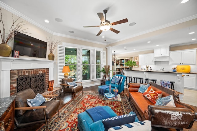 living room with crown molding, a fireplace, ceiling fan, and hardwood / wood-style flooring