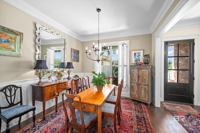 dining room with an inviting chandelier, crown molding, and dark wood-type flooring