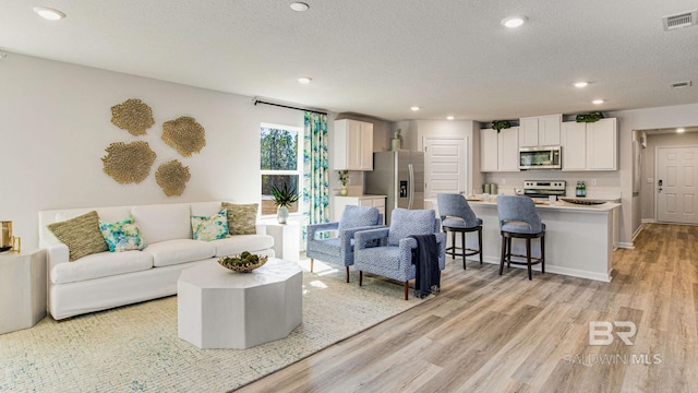 1040 Hayward Loop, Foley, AL 36535 - living room featuring light wood-style floors, recessed lighting, and a textured ceiling