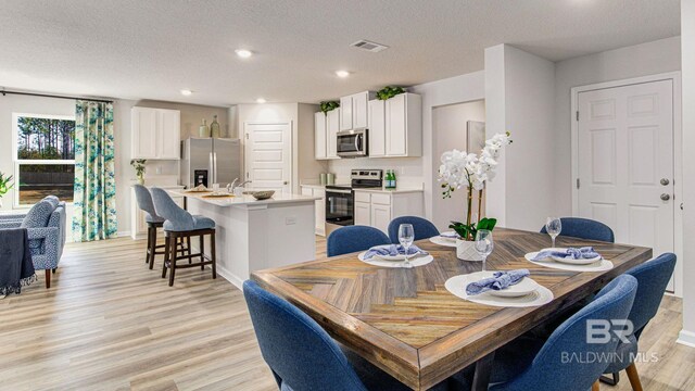 1040 Hayward Loop, Foley, AL 36535 - dining space with light wood finished floors, recessed lighting, and a textured ceiling