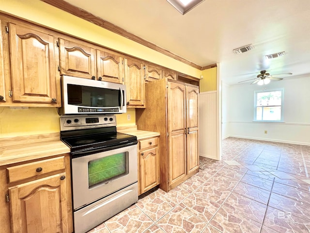 kitchen with appliances with stainless steel finishes, crown molding, and ceiling fan