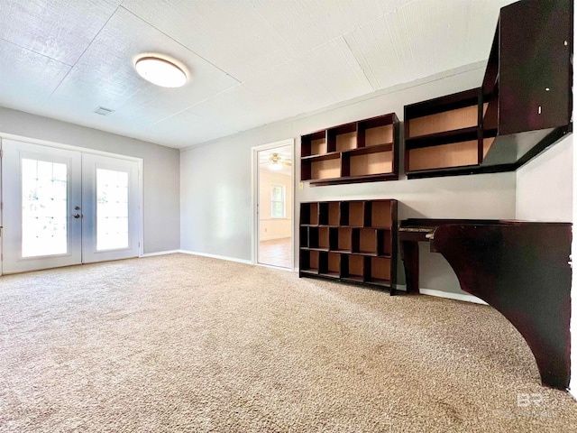 unfurnished living room featuring ceiling fan, carpet floors, and french doors