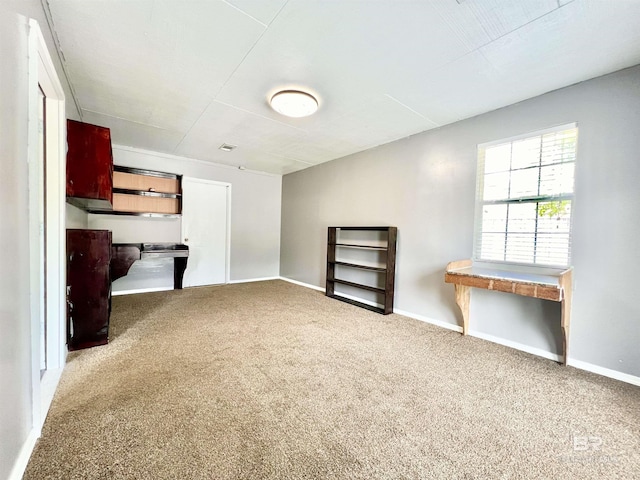 unfurnished living room with carpet floors, baseboards, and visible vents