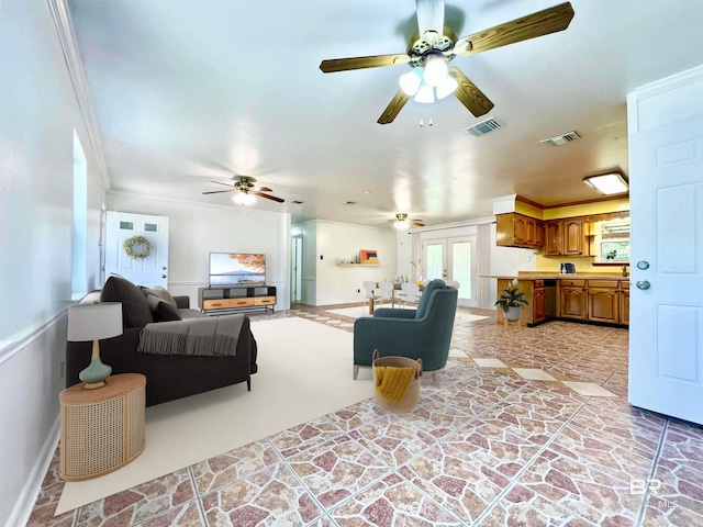 living area featuring crown molding, ceiling fan, baseboards, and visible vents