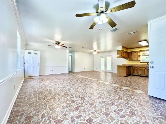 unfurnished living room with ornamental molding, baseboards, a ceiling fan, and visible vents