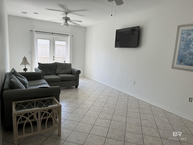 tiled living room featuring ceiling fan and french doors