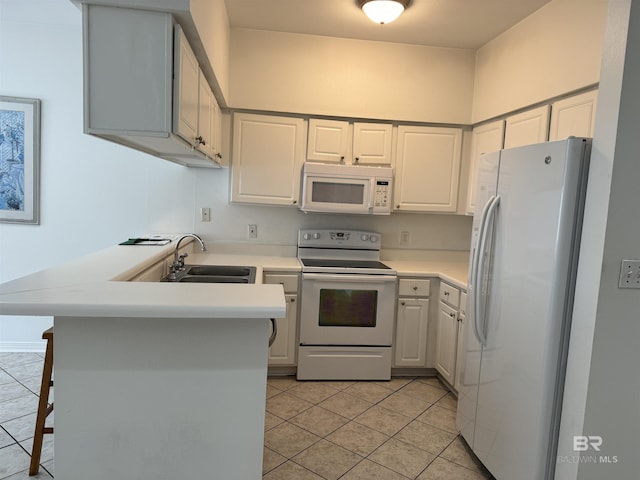 kitchen with white appliances, white cabinets, sink, kitchen peninsula, and a breakfast bar area