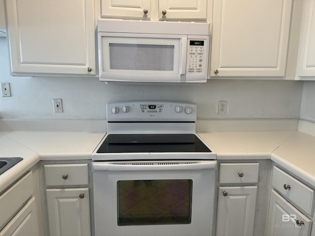 kitchen featuring white cabinetry and white appliances