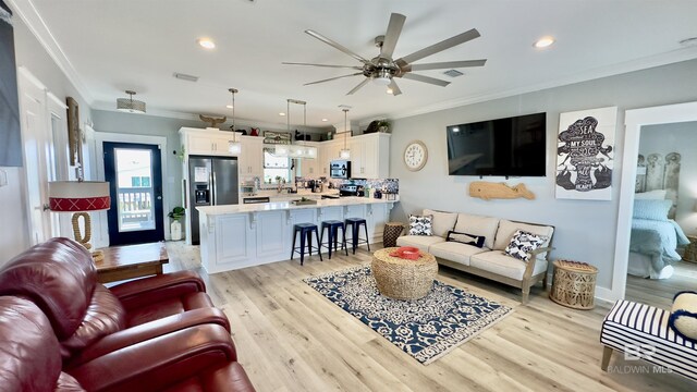 living room featuring crown molding, light hardwood / wood-style flooring, and ceiling fan