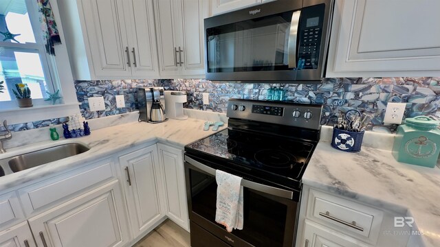 kitchen featuring decorative backsplash, stainless steel appliances, and white cabinets