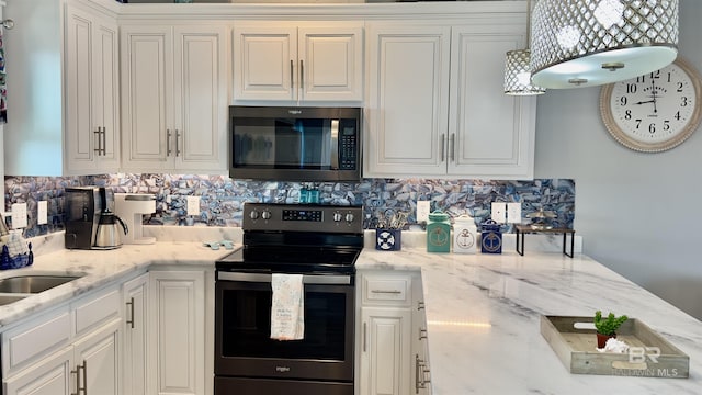 kitchen with tasteful backsplash, appliances with stainless steel finishes, white cabinets, and light stone counters