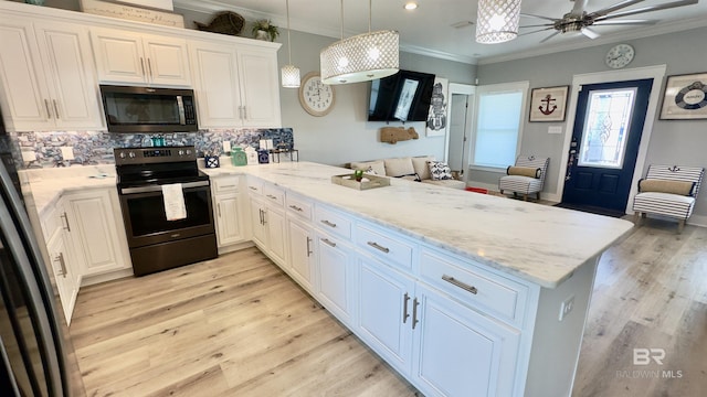 kitchen featuring hanging light fixtures, kitchen peninsula, white cabinets, and appliances with stainless steel finishes