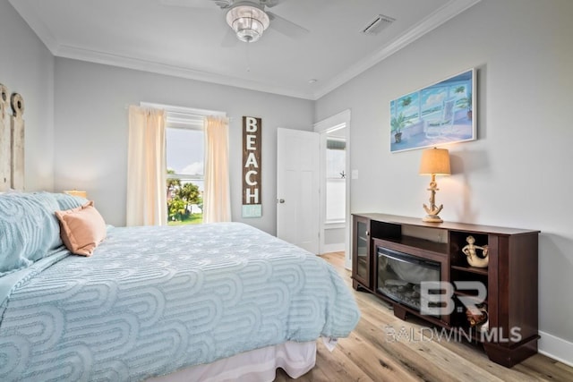 bedroom with ceiling fan, light hardwood / wood-style flooring, and ornamental molding