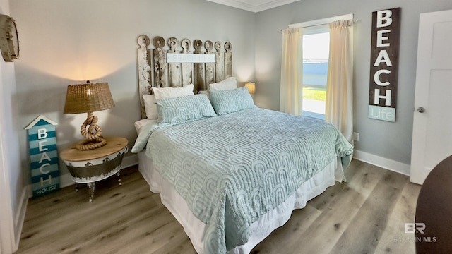 bedroom with wood-type flooring and ornamental molding