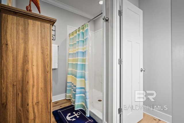 bathroom featuring ornamental molding, wood-type flooring, and walk in shower