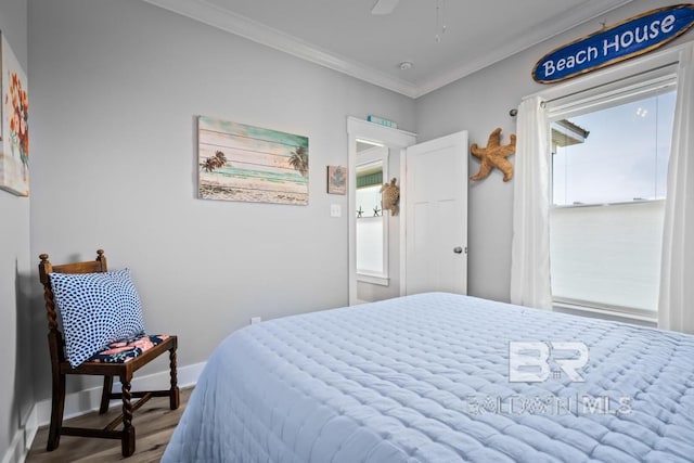 bedroom with multiple windows, ornamental molding, wood-type flooring, and ceiling fan