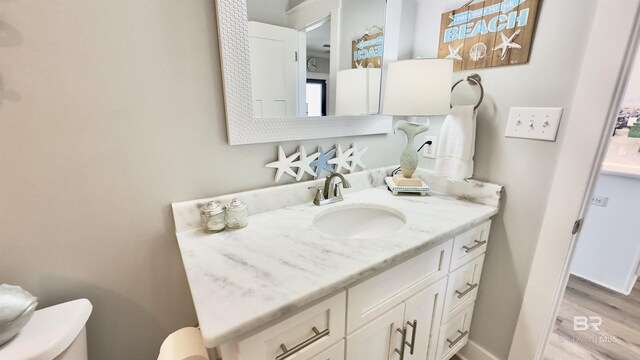 bathroom featuring vanity, hardwood / wood-style flooring, and toilet