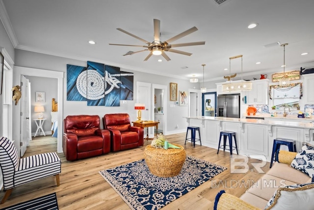 living room with ceiling fan, light hardwood / wood-style flooring, and ornamental molding