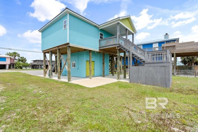 rear view of property featuring a lawn and a carport