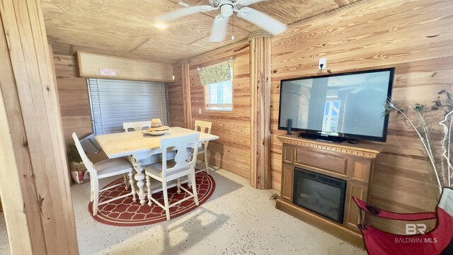 dining area with ceiling fan, wood ceiling, and wooden walls